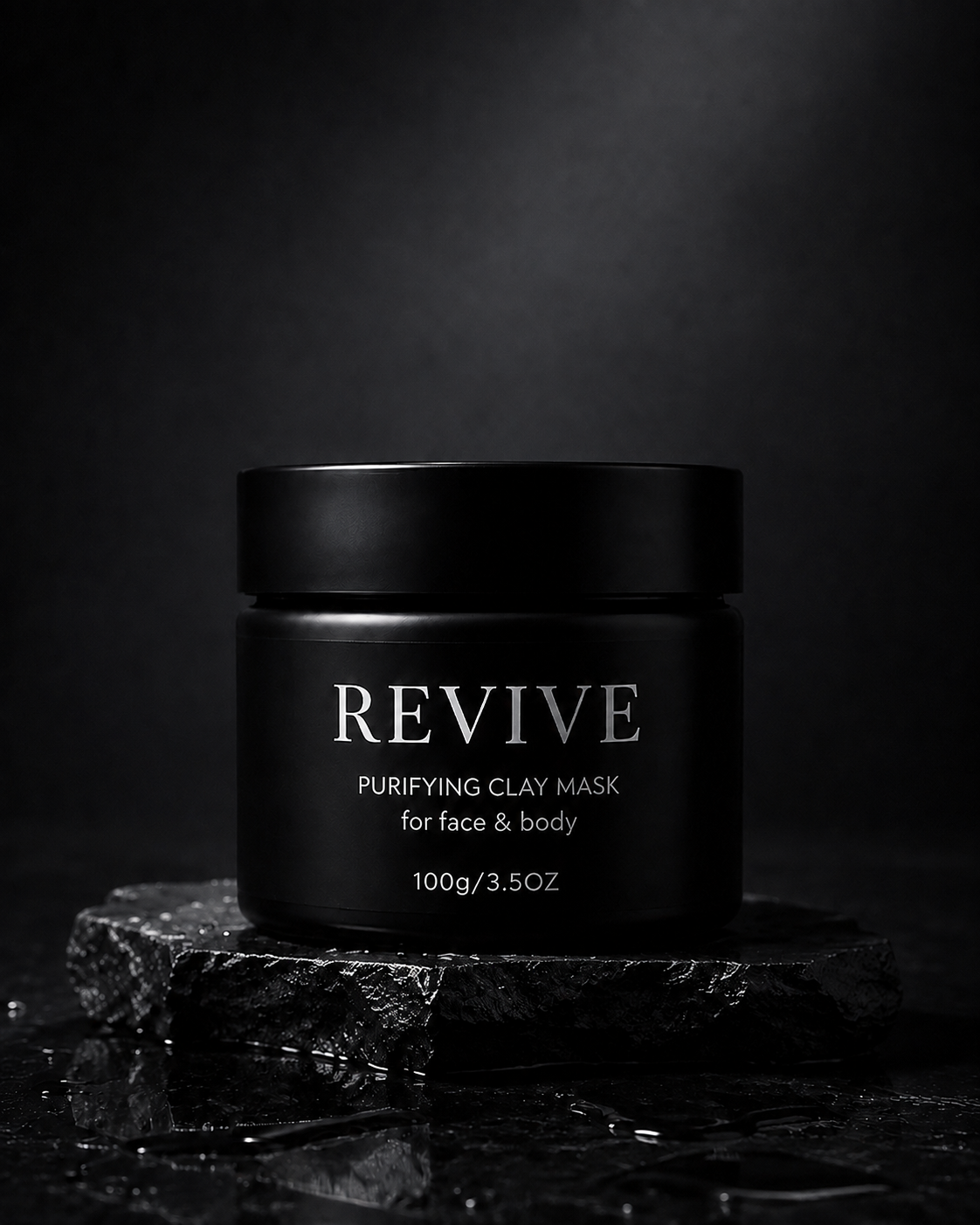 Closed black REVIVE Purifying Clay Mask jar, 100g, standing on a wet slate slab against a dark background
